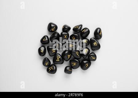 rune stones with black symbols for fortune telling Stock Photo - Alamy