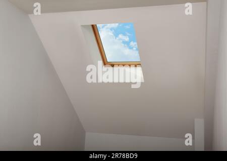 Skylight roof window and lamps on slanted ceiling in attic room, low angle view Stock Photo