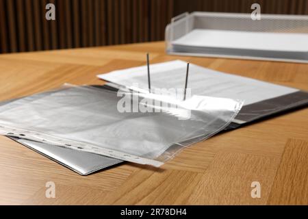 File folder with punched pockets on wooden table, closeup Stock Photo