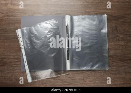 File folder with punched pockets on wooden table, flat lay Stock Photo