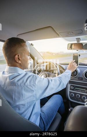 Driver using a mobile phone inside his car. Stock Photo