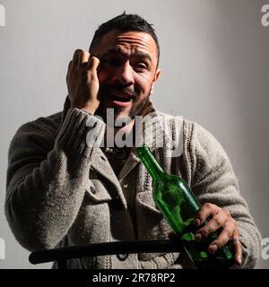 Alcoholic man with bottles wine cry. Depressed crying man. Drunk alcohol addict man drinking whiskey, depressed as alcoholic suffering alcoholism Stock Photo