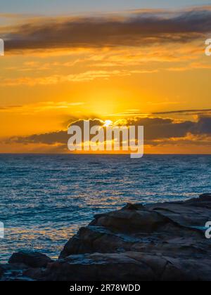 Sunrise seascape with clouds and sun at Avoca Beach on the Central ...