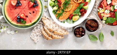 Dinner table with shrimp, fish, salads and different snacks on a white background. Top view. Panorama. Stock Photo