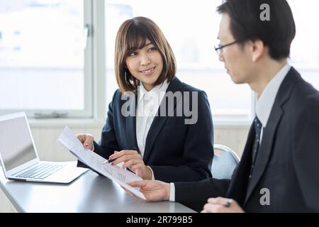 Asian business woman smiling and checking documents Stock Photo