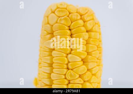 Peeled corn on a white background. Sweet corn vegetables, fresh peeled saw yellow corn kernels. Stock Photo