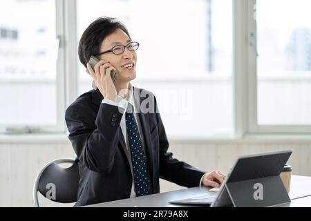 Asian businessman making a phone call Stock Photo