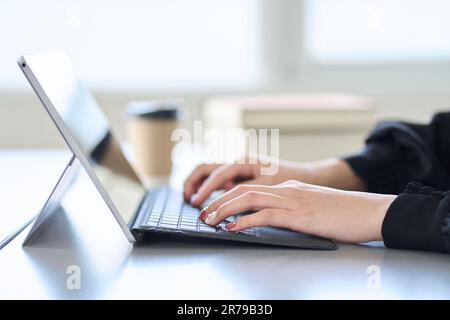 Asian woman typing on laptop Stock Photo