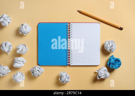 Notebook and paper balls on yellow background, top view Stock Photo