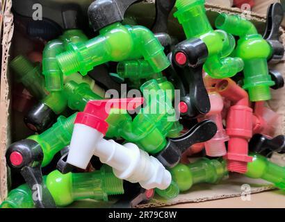 Pile of colorful plastic faucets in boxes, on the market at a hardware store Stock Photo