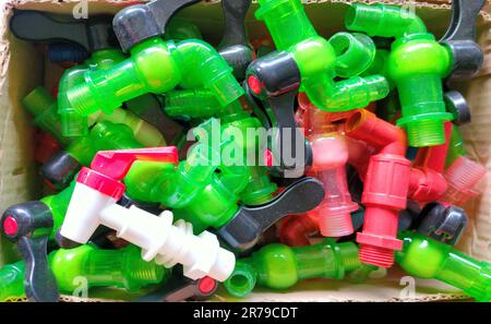 Pile of colorful plastic faucets in boxes, on the market at a hardware store Stock Photo