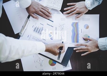 Business colleagues working and analyzing financial figures on a graphs Stock Photo