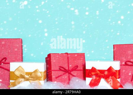 Closeup of different colorful gift boxes in a row with beautiful decorations and bows isolated on Light Blue. Gift boxes on a white table stand in a r Stock Photo