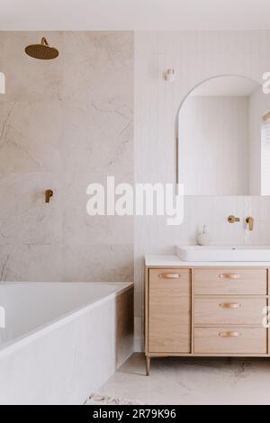 A modern bathroom featuring a white porcelain sink in front of a large mirror Stock Photo