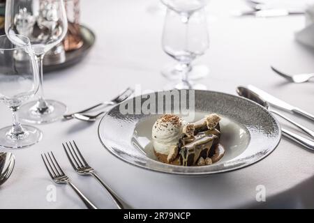Chocolate brownies topped with caramel and a bowl of whipped cream. Stock Photo