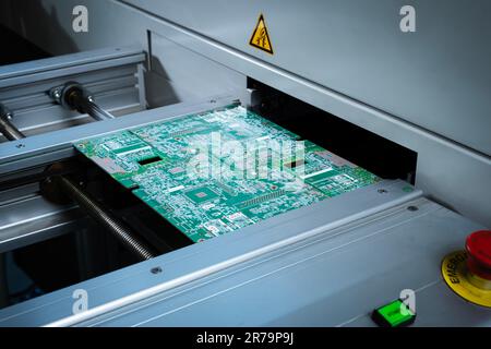 Automatic machine for diagnostics of electronic boards, production. Automatic robot for print circuit board (PCB)assembly machine during soldering or Stock Photo