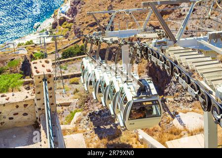 View of Santorini Cable car moving down on the steep cliff face of the Caldera from Fira or Thera capital town to the port at Aegean Sea,Cyclades,Sant Stock Photo