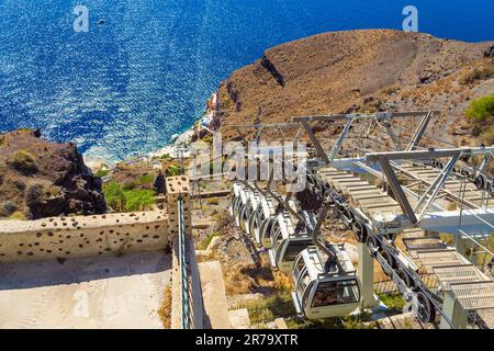 View of Santorini Cable car moving down on the steep cliff face of the Caldera from Fira or Thera capital town to the port at Aegean Sea,Cyclades,Sant Stock Photo