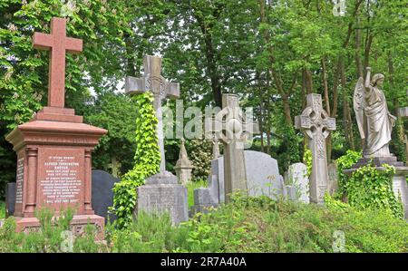 Stone crosses and grave monuments among dense greenery in Highgate Cemetery, a historic Victorian burial ground in North London, England, UK. Stock Photo