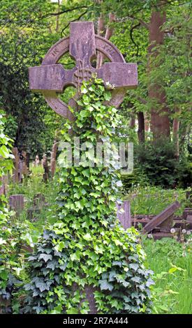 Stone crosses and grave monuments among dense greenery in Highgate Cemetery, a historic Victorian burial ground in North London, England, UK. Stock Photo