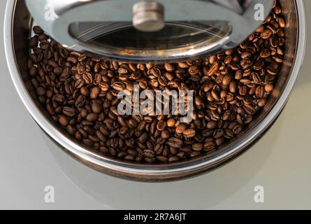 Freshly roasted coffee beans in the cooling tray of a countertop home coffee roaster. Stock Photo