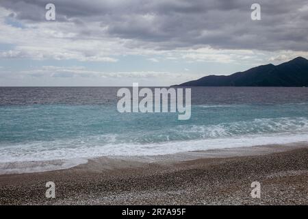 Tranquil Shoreline: a Scenic Ocean Beach with Rolling Waves and Blue Sky Stock Photo