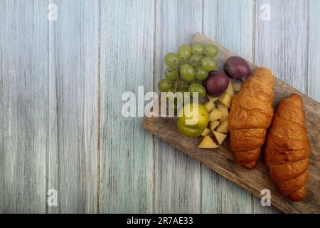 A colorful platter of freshly prepared food consisting of golden croissants, juicy oranges and a variety of other fresh fruits Stock Photo