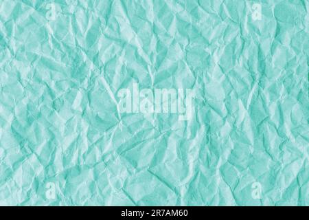 Recycled crumpled turquoise paper texture background. Wrinkled and creased abstract backdrop, wallpaper with copy space, top view. Stock Photo
