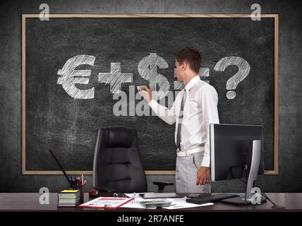 businessman in office drawing money formula on blackboard Stock Photo