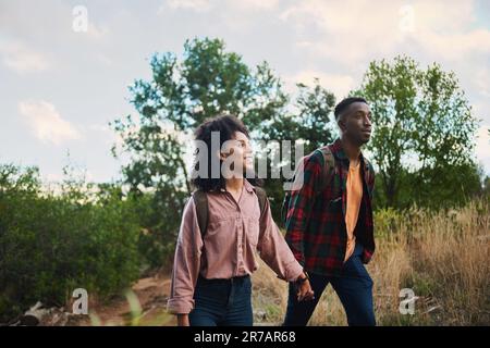 Smiling young multiethnic couple hiking together in some hills Stock Photo