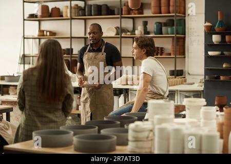 Diverse group of ceramists talking together in a studio Stock Photo