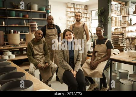 Manager and her diverse team smiling in a ceramics studio Stock Photo