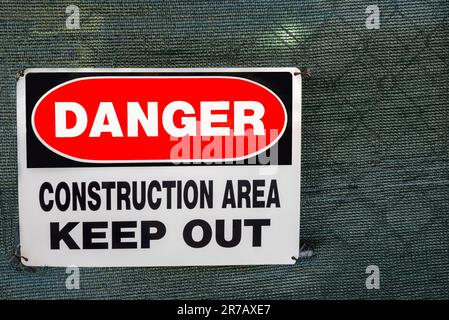 Close up of a keep out warning sign on a covered chain-link fence surrounding a construction area Stock Photo