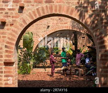 View through arches with kids in art workshop. Subteranian Ruins, Kaggalipura, Bangalore, India. Architect: A Threshold Architects, 2023. Stock Photo