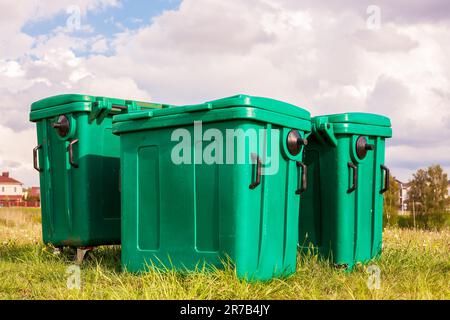 Plastic rubbish bins against a backdrop of grass and bright sky Stock Photo