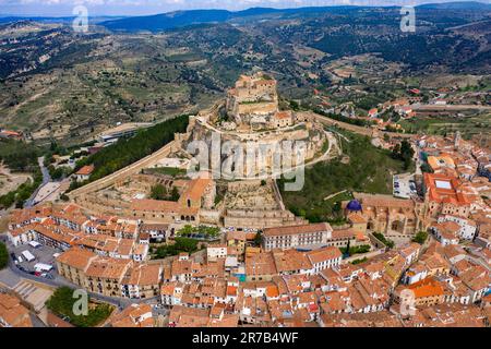 Aerial sunset view of Morella, medieval walled town with semi circular towers and gate houses crowed by a fortress on the rock in Spain, Valencia comu Stock Photo