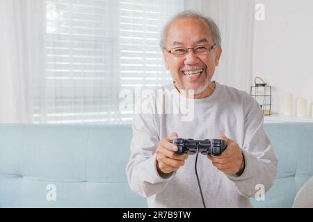 Senior man using joystick, Senior holding joystick to play game Stock Photo
