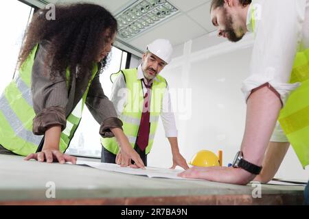 Construction engineers team using blueprint of project plan Stock Photo