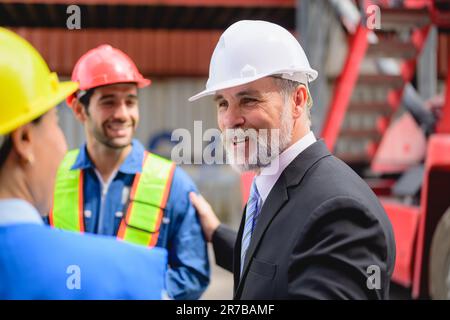 Businessman talking with engineers at industrial container yard Stock Photo