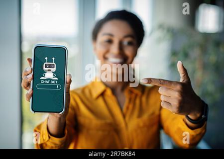 Phone with chat bot on screen in african woman hand Stock Photo