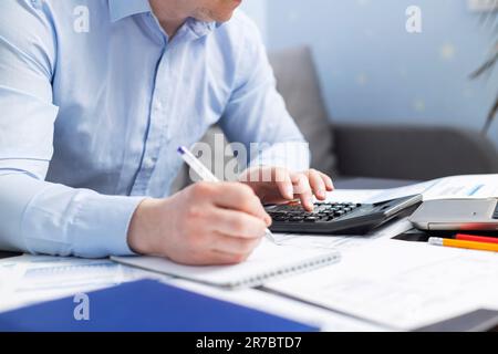 Businessman using calculator to calculate bills at the table in office Stock Photo