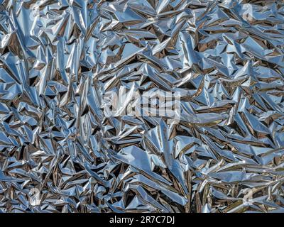 Crumpled aluminium foil, silver texture, abstract background Stock Photo
