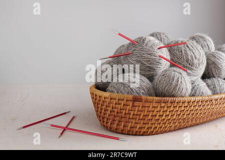 Double pointed knitting needles and balls of yarn in basket Stock Photo