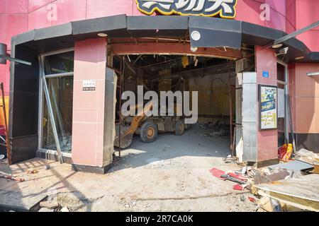 SHENZHEN, CHINA - 27 NOVEMBER, 2019: loader inside under construction Kungfu fast food restaurant building in Shenzhen. Stock Photo