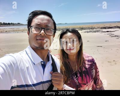 A smiling man and woman pose together while taking a selfie Stock Photo