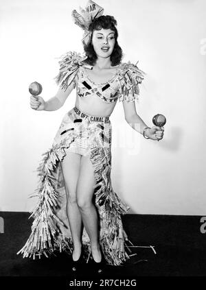 Hollywood, California:   c. 1941 Actress Mary Brodel dons her newspaper headlines and performs a War Extra dance with maracas. Stock Photo