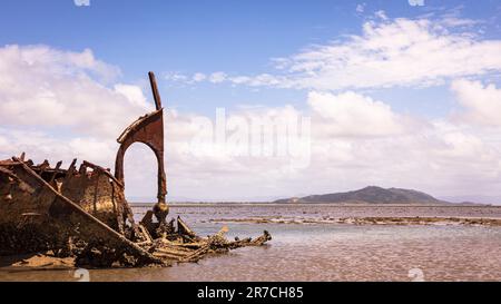 shipwreck on magnetic island with mountains of Townsville behind Stock Photo