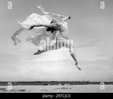 St. Petersburg, Florida:  c. 1934. An exuberant soaring dance to spring by a young woman on the beaches of Florida. Stock Photo