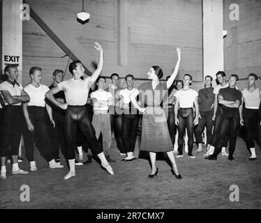 Hollywood, California:  c. 1955 Dancers Gene Kelly and Alicia Alonso demonstrating a position to a class of male dancers. Stock Photo