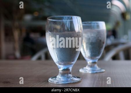 https://l450v.alamy.com/450v/2r7cnbx/two-glasses-of-water-on-table-misted-glass-cold-drink-pure-water-diet-health-dripping-droplets-flow-down-glass-wooden-table-blurred-background-on-empty-stomach-drinking-clean-water-spring-water-2r7cnbx.jpg